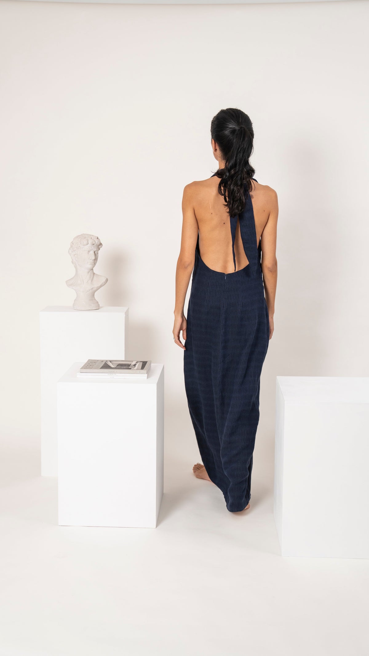 Vestido largo de lino azul con espalda completamente descubierta y amarra al cuello, vista de espalda
